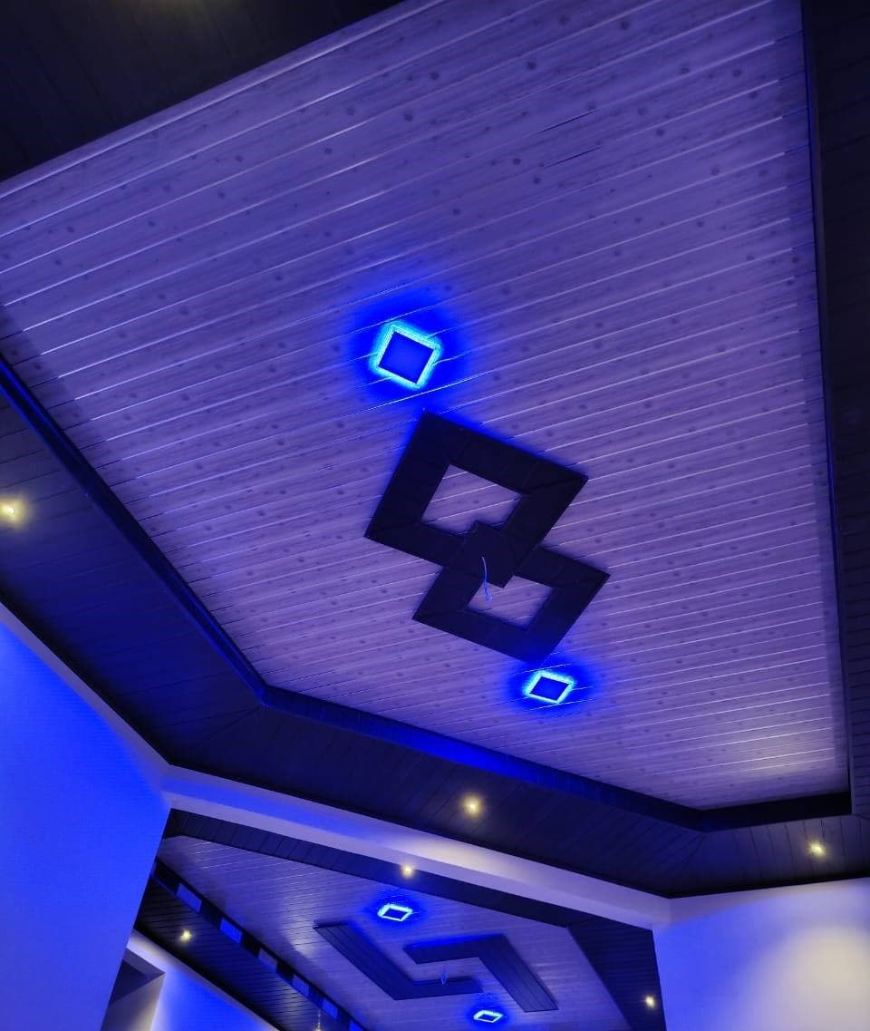 I-Panel ceiling with white slats, dark border trim, and modern chandelier
